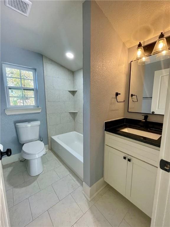 full bathroom with a textured ceiling, lofted ceiling, toilet, vanity, and tiled shower / bath