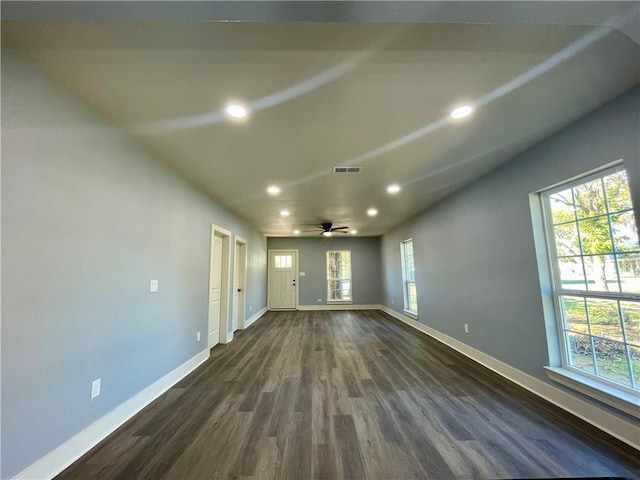 spare room with dark hardwood / wood-style floors, ceiling fan, and a healthy amount of sunlight