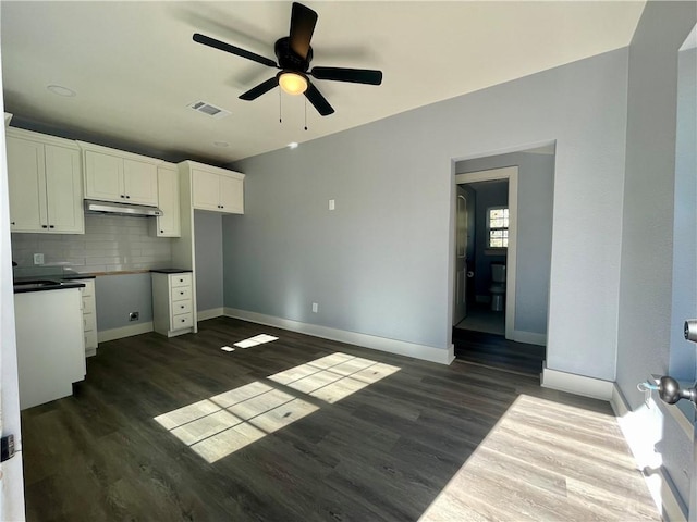 kitchen with white cabinets, dark hardwood / wood-style floors, ceiling fan, and decorative backsplash