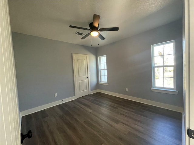 spare room with dark hardwood / wood-style floors, ceiling fan, and a textured ceiling