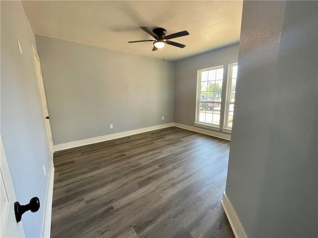 empty room with a textured ceiling, ceiling fan, and dark wood-type flooring