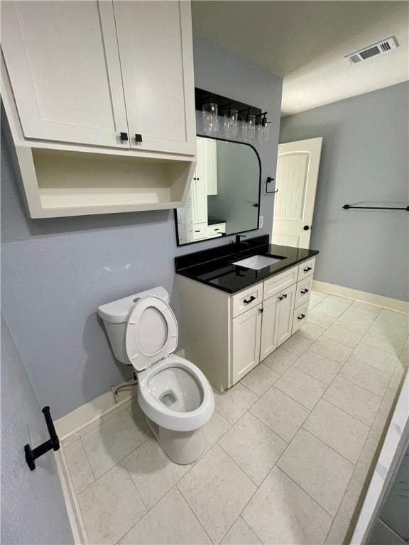 bathroom featuring tile patterned floors, vanity, and toilet