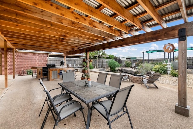 view of patio / terrace with an outdoor fire pit and exterior kitchen