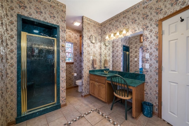 bathroom with tile patterned flooring, vanity, toilet, and a shower with shower door