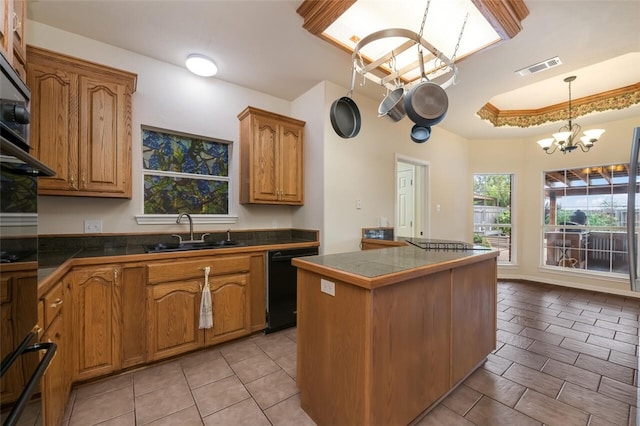 kitchen featuring dishwasher, a center island, an inviting chandelier, sink, and hanging light fixtures