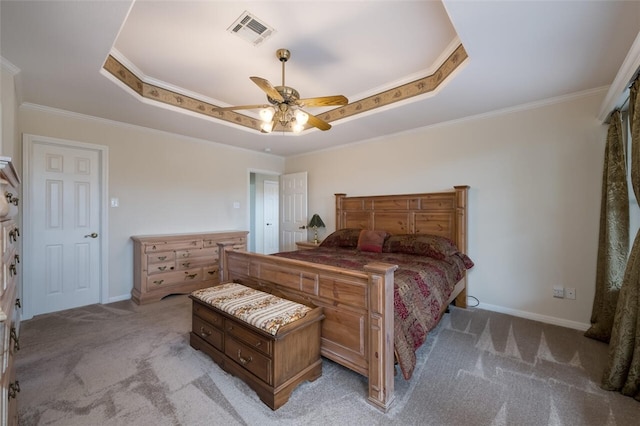 bedroom featuring light carpet, a tray ceiling, ceiling fan, and ornamental molding