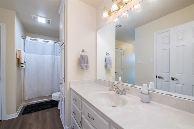 bathroom with vanity, hardwood / wood-style flooring, toilet, and walk in shower