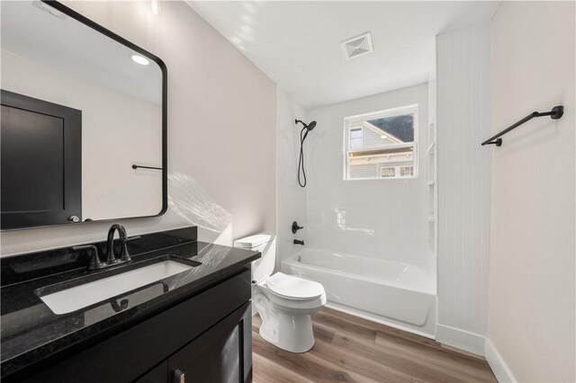 full bathroom featuring vanity, hardwood / wood-style floors,  shower combination, and toilet