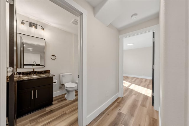 bathroom with hardwood / wood-style floors, vanity, and toilet