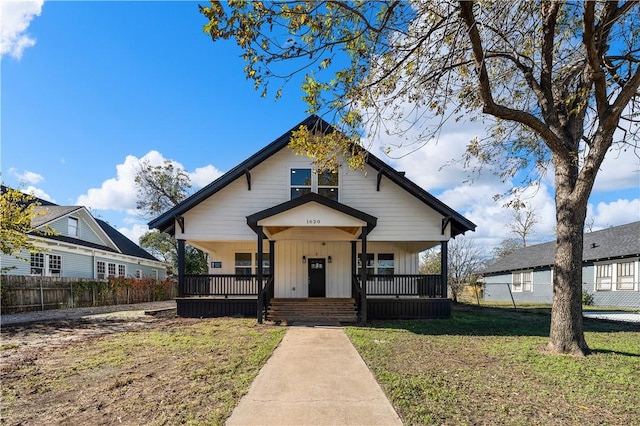 bungalow-style house featuring covered porch and a front yard