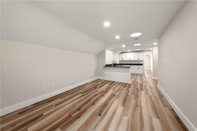 unfurnished living room featuring light hardwood / wood-style floors and sink