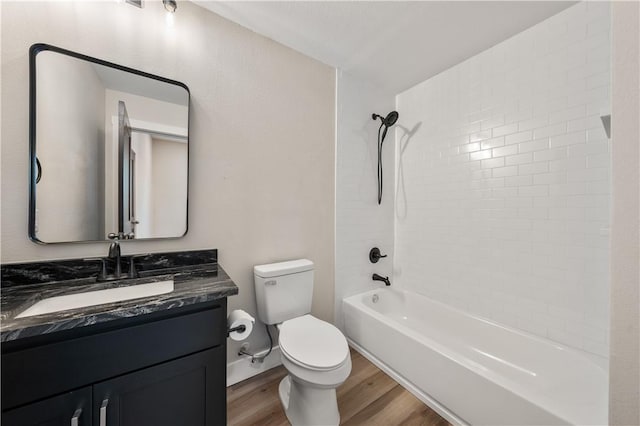 full bathroom with vanity, wood-type flooring, tiled shower / bath combo, and toilet