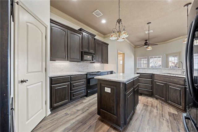 kitchen featuring black appliances, light wood finished floors, a sink, and visible vents