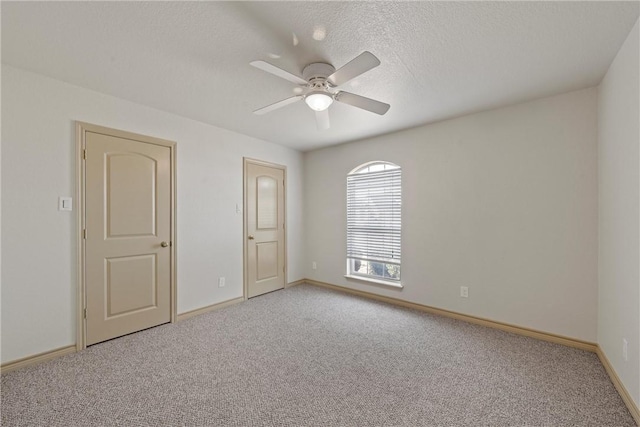 unfurnished room featuring light carpet, ceiling fan, baseboards, and a textured ceiling