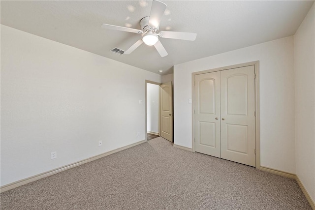 unfurnished bedroom featuring light colored carpet, a closet, visible vents, and baseboards