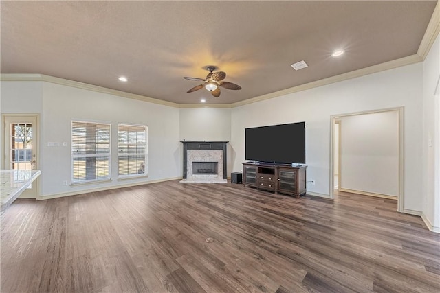 unfurnished living room featuring a tiled fireplace, dark wood finished floors, a ceiling fan, and baseboards