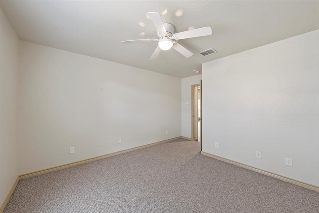 spare room featuring baseboards, visible vents, a ceiling fan, and light colored carpet