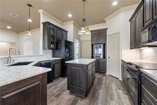 kitchen with dark brown cabinetry, visible vents, a sink, and black appliances