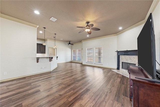 living area with visible vents, dark wood finished floors, a ceiling fan, crown molding, and a high end fireplace