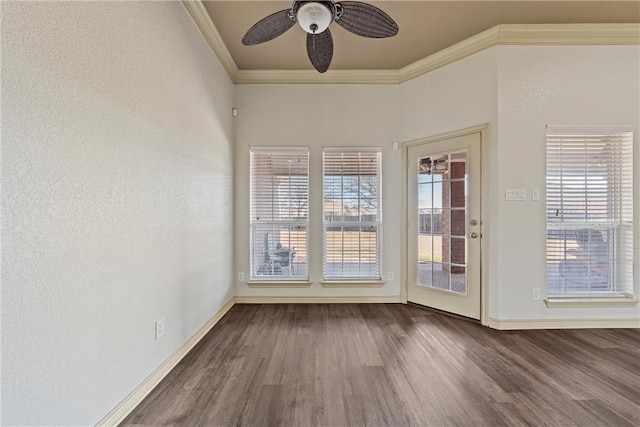 interior space featuring ceiling fan, ornamental molding, wood finished floors, and baseboards