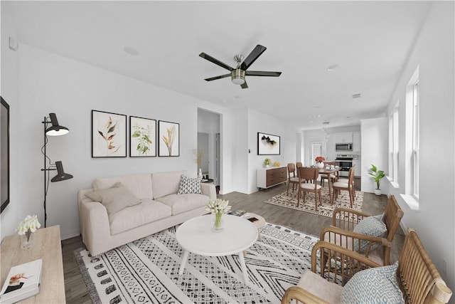 living room with dark hardwood / wood-style floors and ceiling fan