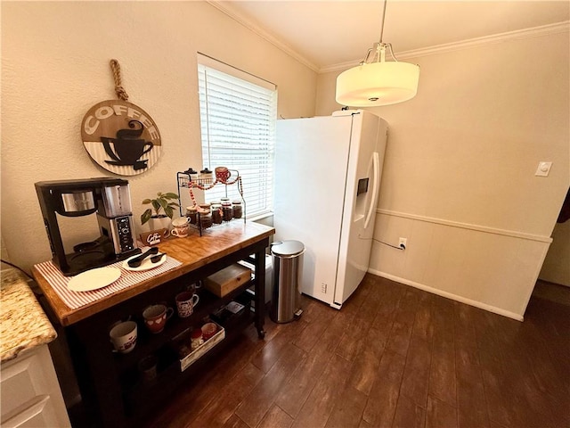 kitchen with hanging light fixtures, crown molding, white refrigerator with ice dispenser, and dark hardwood / wood-style flooring