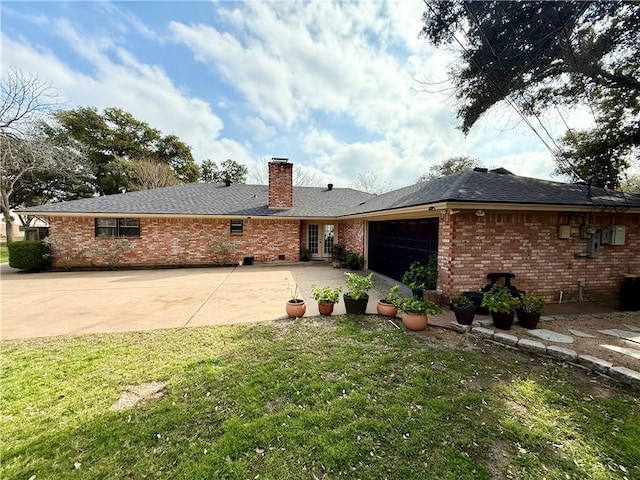 rear view of house with a garage and a lawn