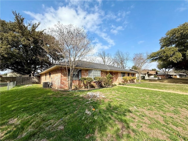 ranch-style home with cooling unit and a front lawn