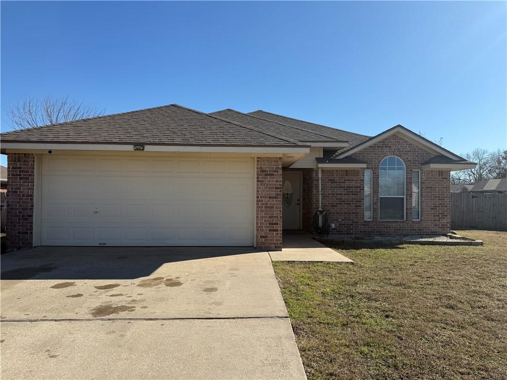 ranch-style home featuring a garage and a front yard