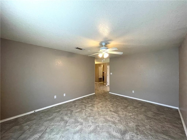 empty room with ceiling fan and a textured ceiling