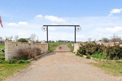 view of road featuring driveway, a gated entry, and a gate