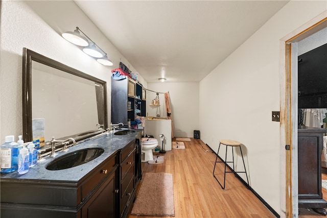 kitchen featuring light wood-type flooring, dark brown cabinetry, and sink