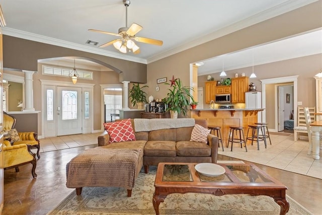 tiled living room with ceiling fan, ornate columns, and crown molding