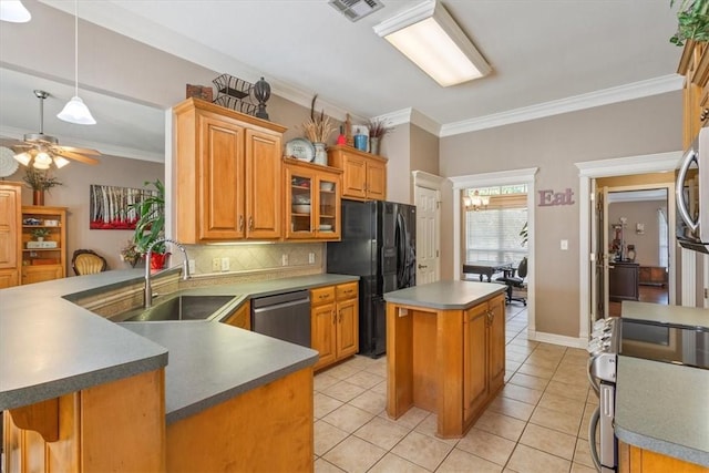 kitchen with kitchen peninsula, appliances with stainless steel finishes, tasteful backsplash, crown molding, and sink