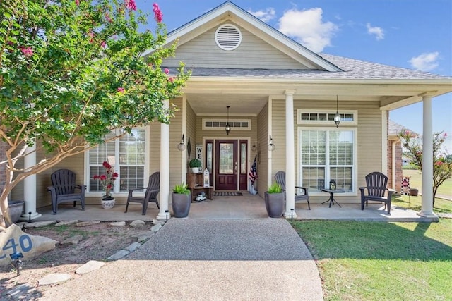 property entrance featuring a lawn and covered porch