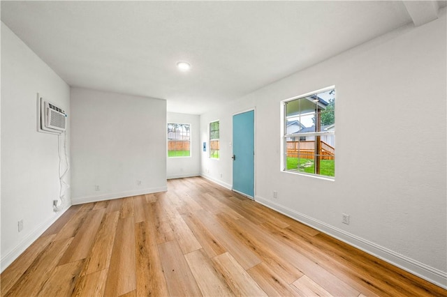 unfurnished room featuring light hardwood / wood-style flooring and a wall unit AC