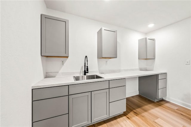 kitchen featuring light hardwood / wood-style flooring, gray cabinetry, and sink