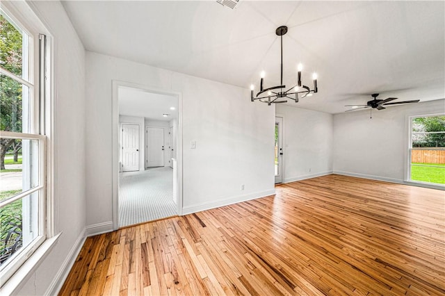 interior space featuring ceiling fan with notable chandelier and light wood-type flooring