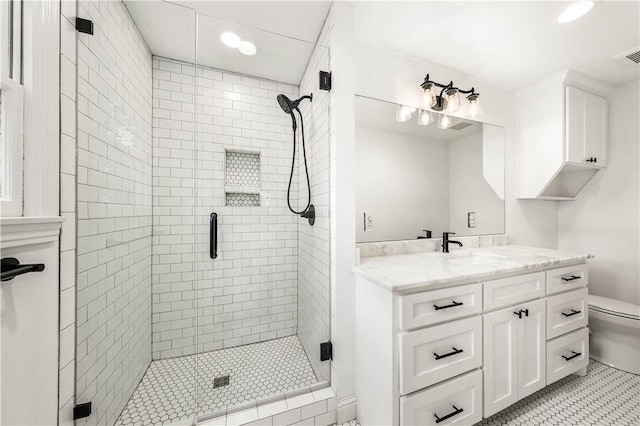 bathroom with tile patterned floors, vanity, a shower with shower door, and toilet