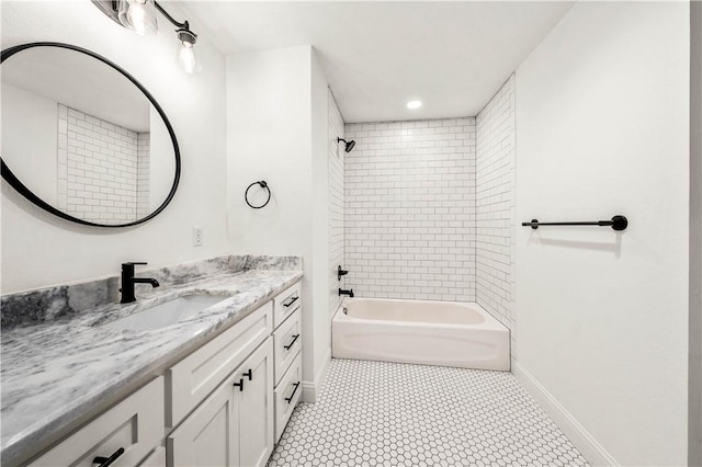 bathroom featuring tile patterned flooring, vanity, and tiled shower / bath