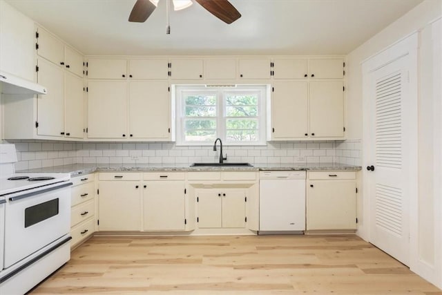 kitchen featuring decorative backsplash, white appliances, light hardwood / wood-style flooring, and sink