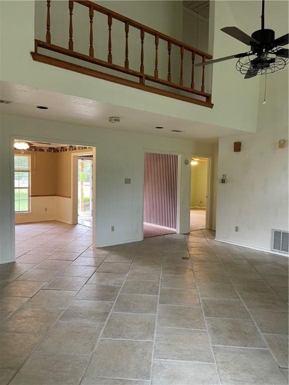 empty room featuring a high ceiling and ceiling fan