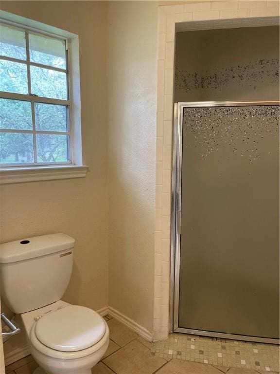 bathroom with tile patterned flooring, toilet, and walk in shower