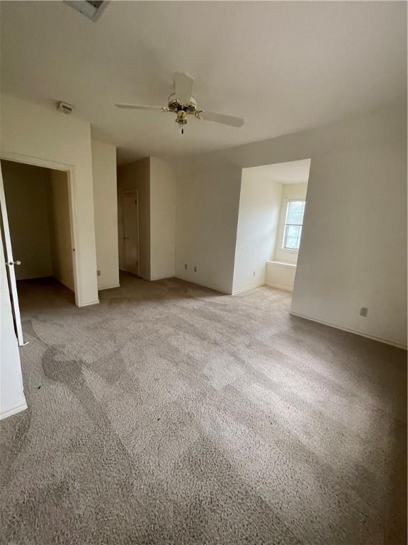 carpeted empty room featuring ceiling fan