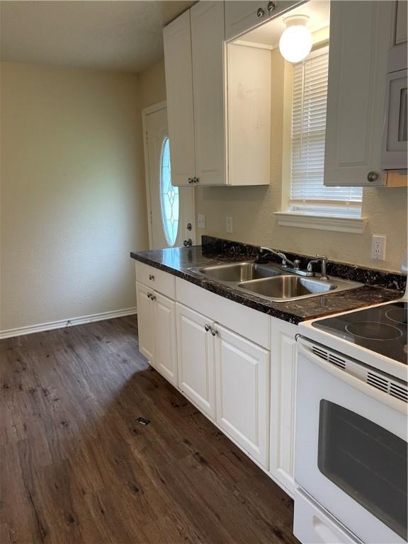 kitchen featuring dark hardwood / wood-style flooring, white appliances, white cabinetry, and sink