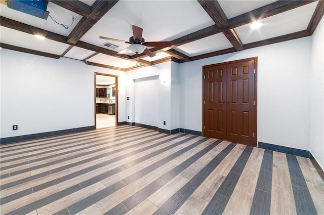 unfurnished room featuring wood-type flooring, ceiling fan, coffered ceiling, and beam ceiling