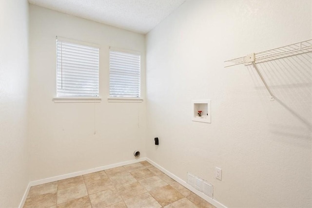 clothes washing area featuring washer hookup, laundry area, visible vents, and baseboards