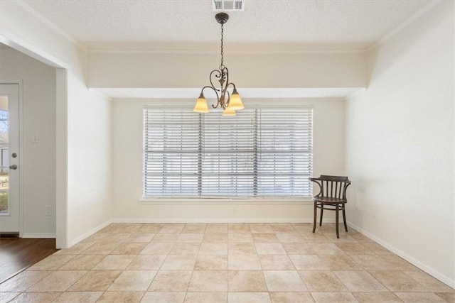 unfurnished dining area featuring a chandelier, ornamental molding, a textured ceiling, and baseboards