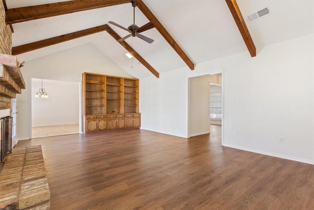 unfurnished living room with ceiling fan with notable chandelier, a fireplace, wood finished floors, visible vents, and beamed ceiling