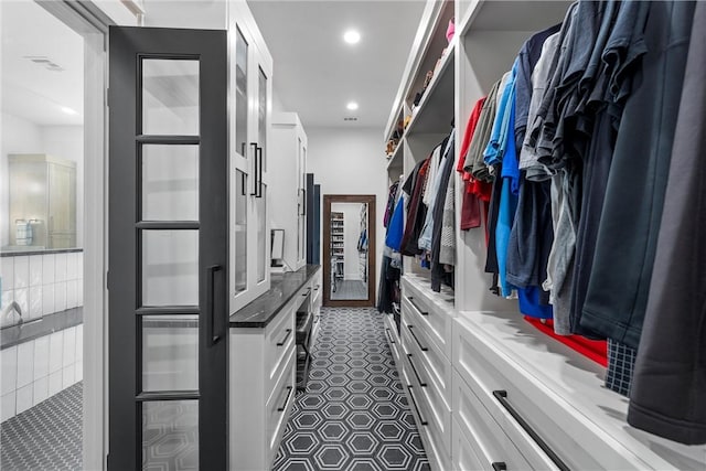 spacious closet featuring dark tile patterned floors